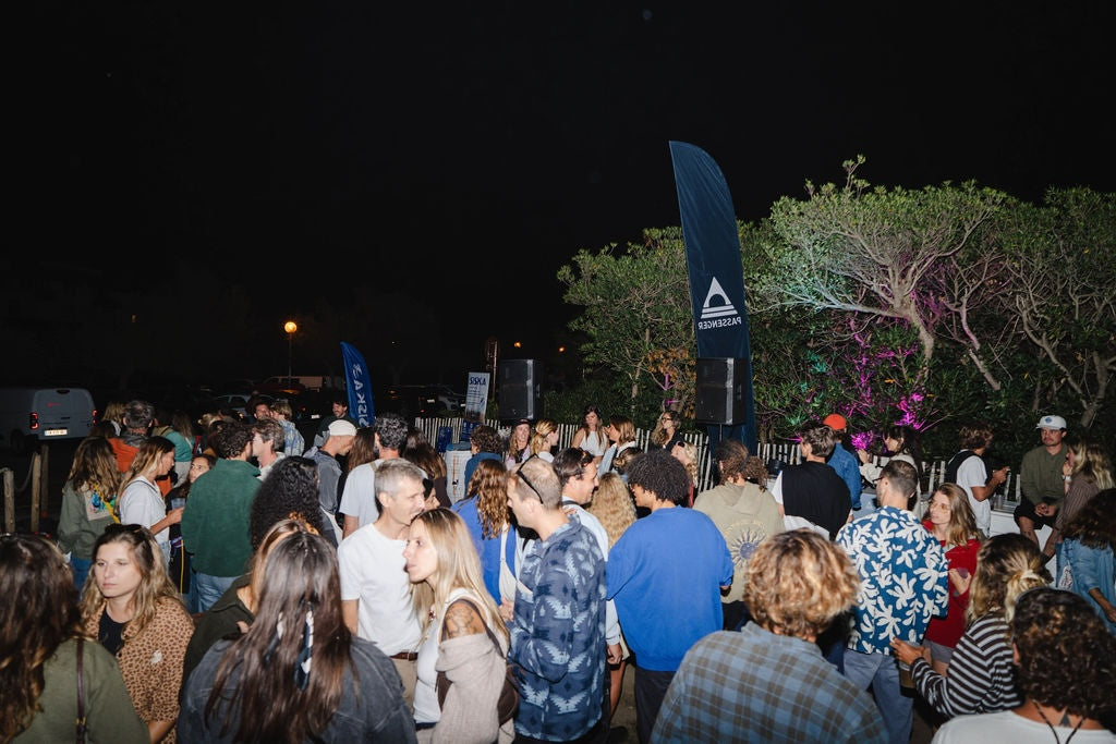 A large group of people dancing and chatting at night time outdoors